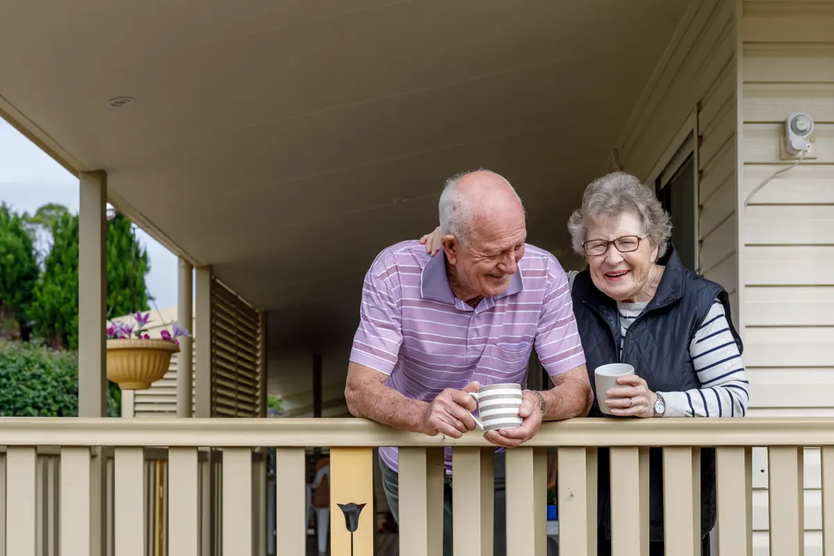An older couple having a cup of tea together on their verandah